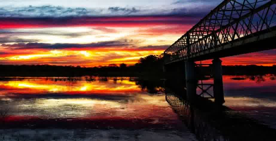 El Puente de la Vía recortado contra el atardecer sobre el río Santa Lucía